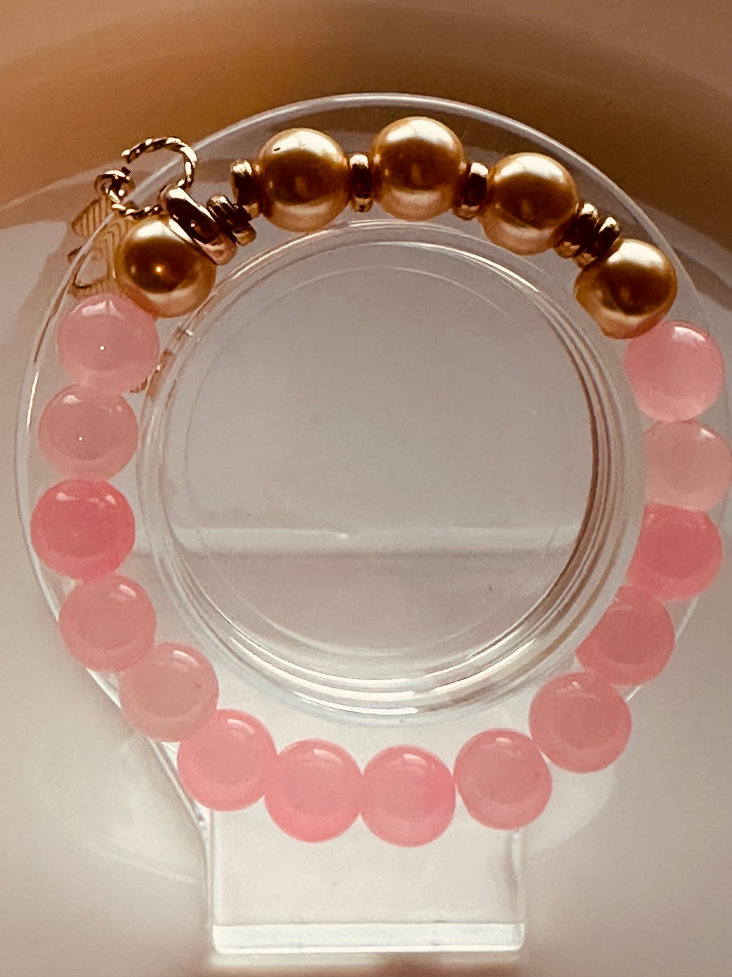 Pink and gold bracelet with a fish charm.